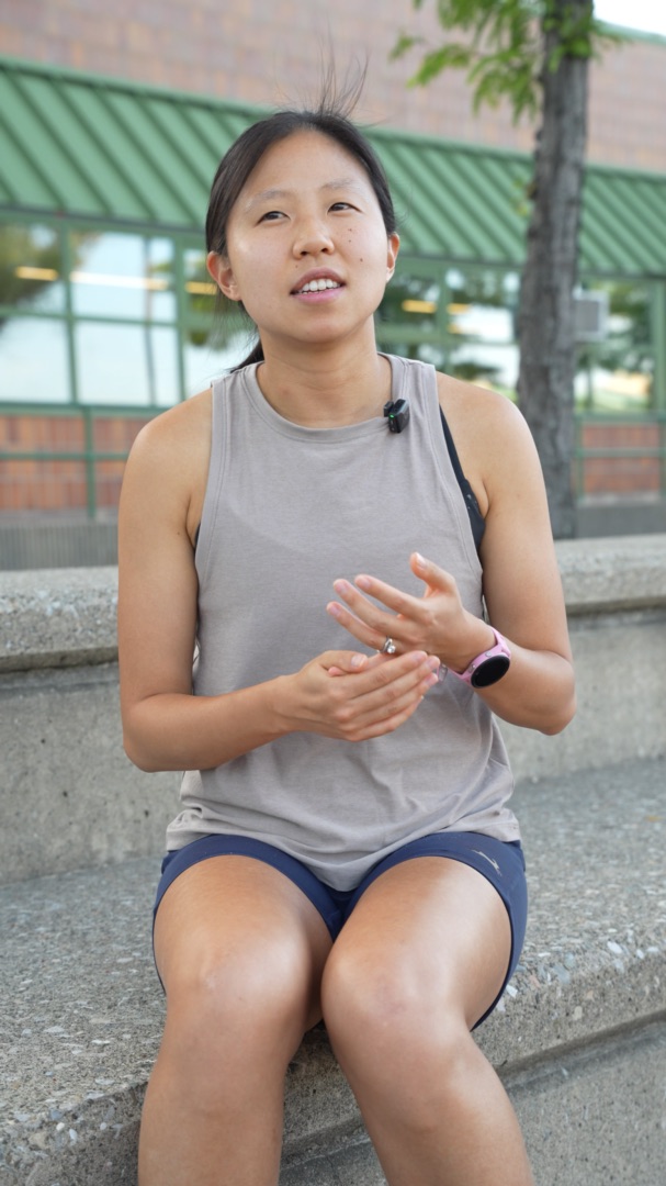 Maryann Gong, founder of Toga, sitting on track bleachers